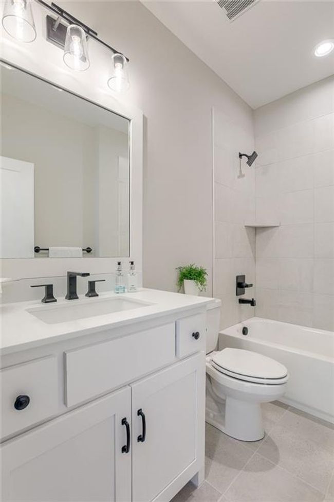 Bathroom featuring vanity, tile patterned flooring, toilet, visible vents, and bathtub / shower combination | Image 23