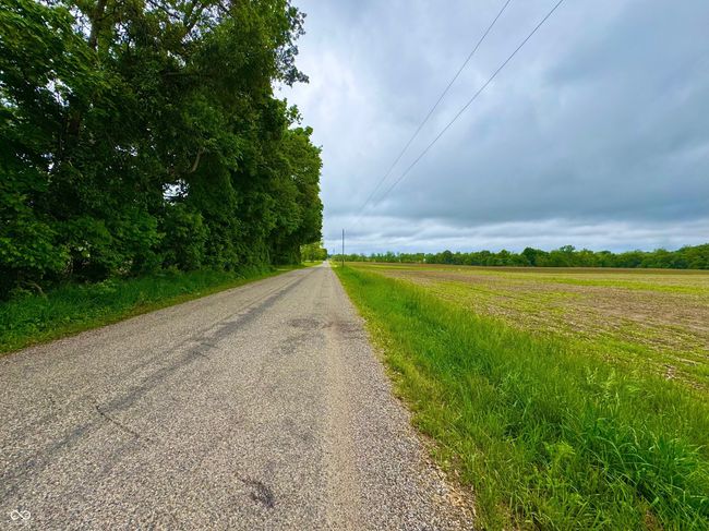 view of asphalt road featuring a view of rural / pastoral area | Image 6