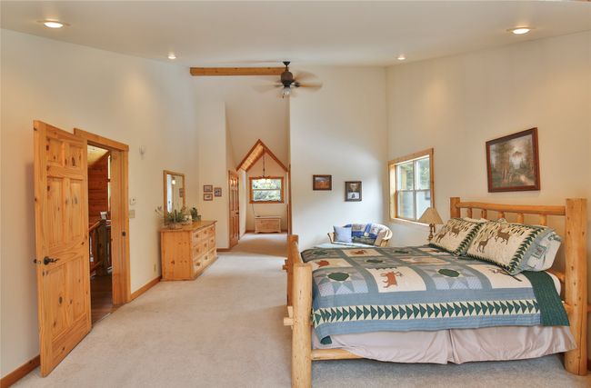 Bedroom featuring light carpet, high vaulted ceiling, a ceiling fan, recessed lighting, and baseboards | Image 36