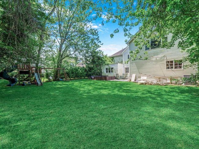 View of grassy yard with a playground and a hot tub | Image 28