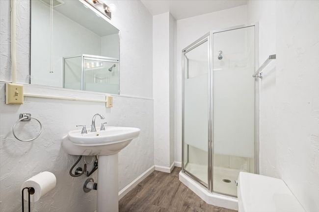 Bathroom featuring an enclosed shower, wood-type flooring, and sink | Image 16