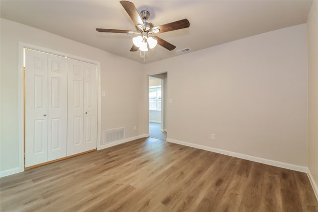 Unfurnished bedroom with light wood-type flooring, a closet, and a ceiling fan | Image 15