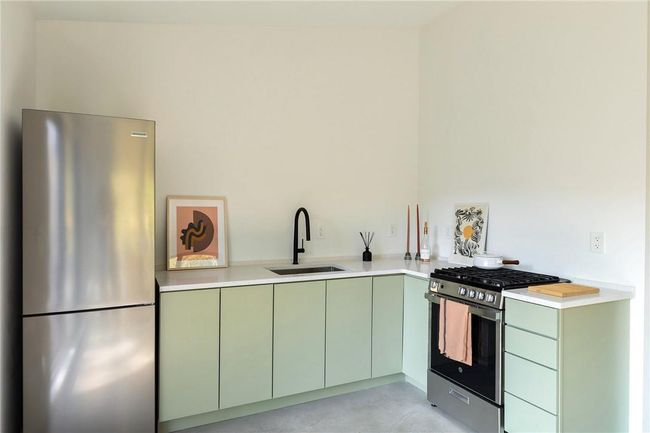 Kitchen with stainless steel appliances, sink, and green cabinets | Image 5