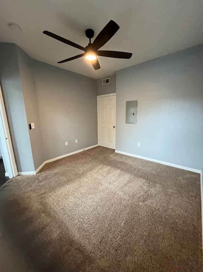 Unfurnished bedroom with electric panel, baseboards, visible vents, carpet, and ceiling fan | Image 20