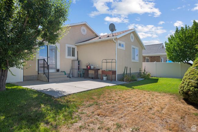 Rear view of house with stucco siding and a patio | Image 28