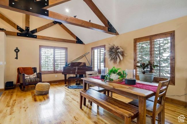 Dining room with high vaulted ceiling, baseboards, beamed ceiling, and wood finished floors | Image 5
