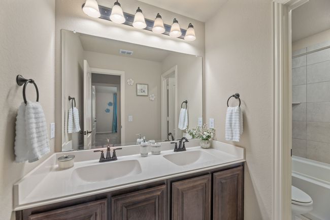 Hall Bathroom featuring double vanity, shower / bathtub combination, and a textured wall | Image 32