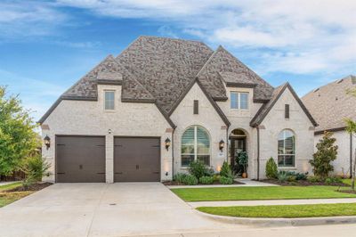 View of front of property with a front yard and a tandem 3 car garage | Image 1