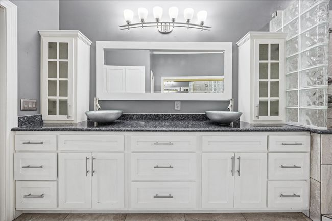 Designer style glass bowl sinks and an extra glass front cabinet provides a luxury feel. | Image 31