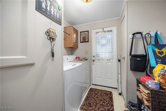 Laundry room featuring cabinet space, separate washer and dryer, and crown molding | Image 28