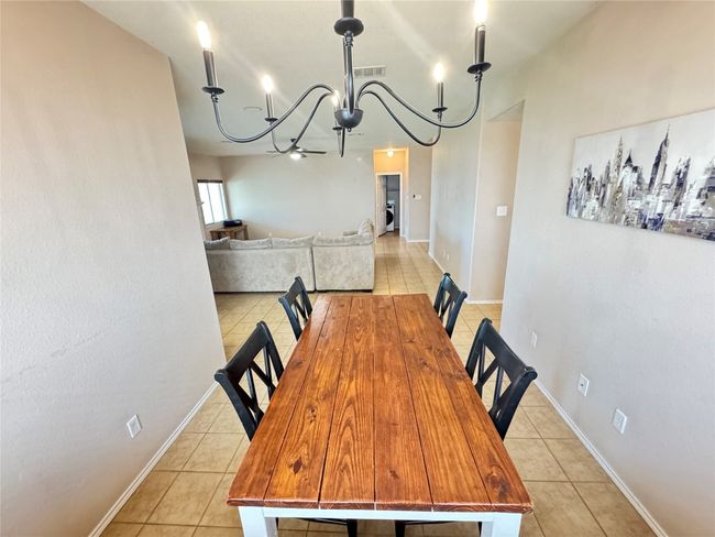 Dining space featuring light tile patterned flooring and a chandelier | Image 16