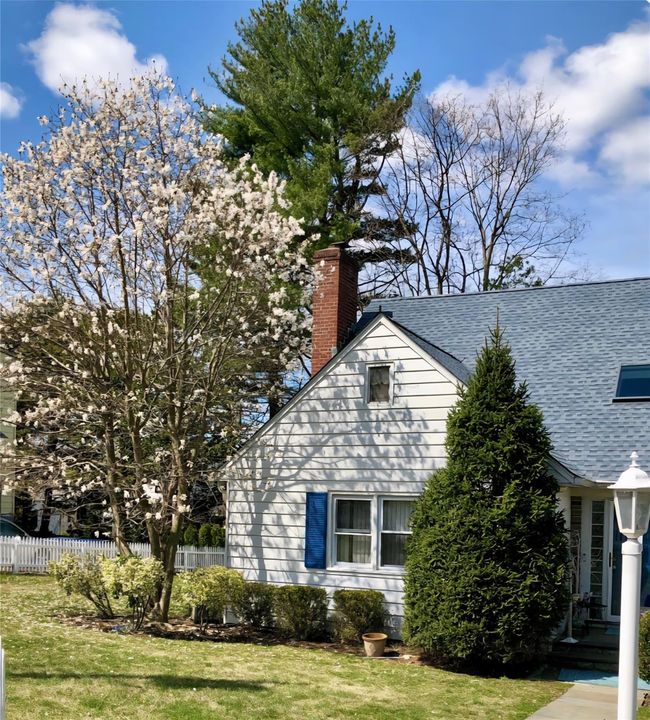 View of property exterior with a chimney and roof with shingles | Image 48