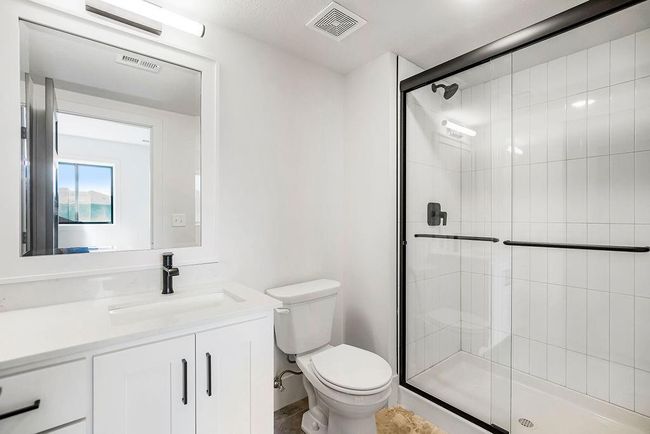 Bathroom with toilet, a shower stall, and vanity | Image 28