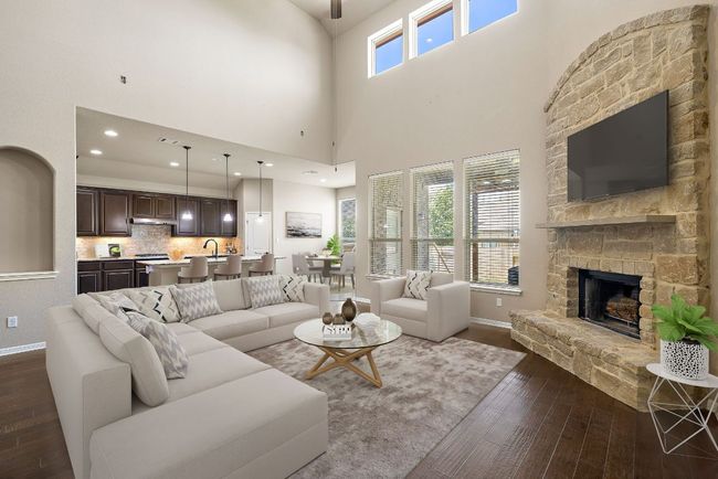 Living room featuring dark wood-type flooring, a fireplace, and a high ceiling | Image 7