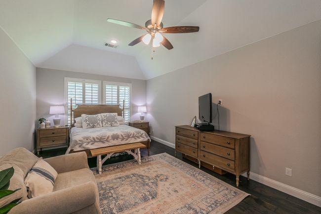 Bedroom with vaulted ceiling, dark wood-style flooring, and ceiling fan | Image 17