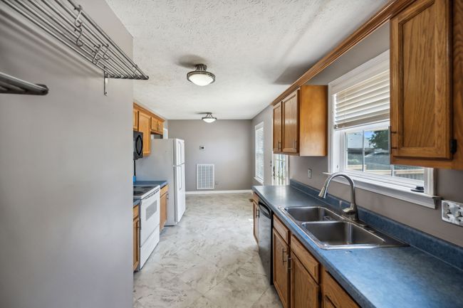 This kitchen is designed for both functionality and comfort and these stainless shelves remain for additional storage, making it the perfect place for casual family meals and entertaining guests! 2095 Bolden Drive, Murfreesboro, TN 37127 | Image 9