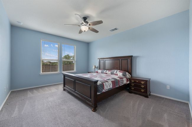 Carpeted bedroom featuring baseboards, visible vents, and ceiling fan | Image 16
