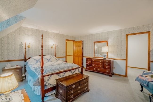 Master bedroom with wallpapered walls and carpet flooring | Image 20
