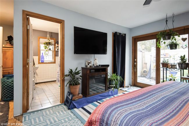 Bedroom featuring connected bathroom, light tile patterned floors, and access to outside | Image 16