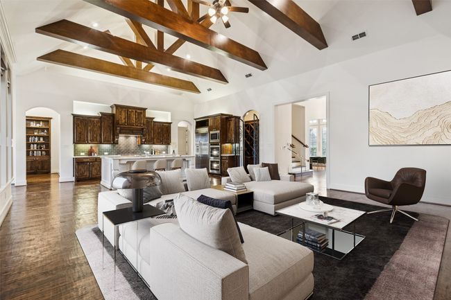 Virtual staging family area with gourmet kitchen view, foyer view, a peek of the library/study room, and stairway to the media room | Image 11