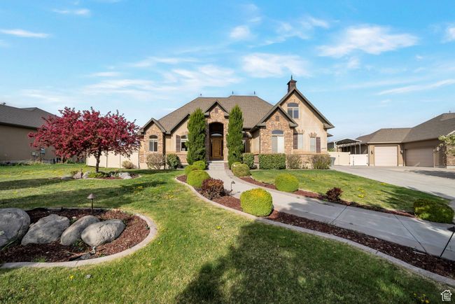 View of front of home featuring fence, a garage, stone siding, a front lawn, and concrete driveway | Image 42