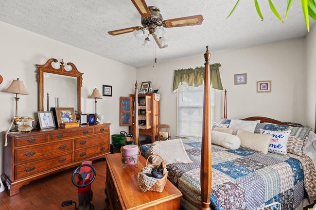 Bedroom featuring wood finished floors, a textured ceiling, and a ceiling fan | Image 16