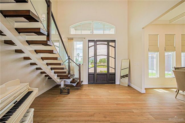 Entrance foyer featuring light porcelain floors, stairway, and a high ceiling | Image 5