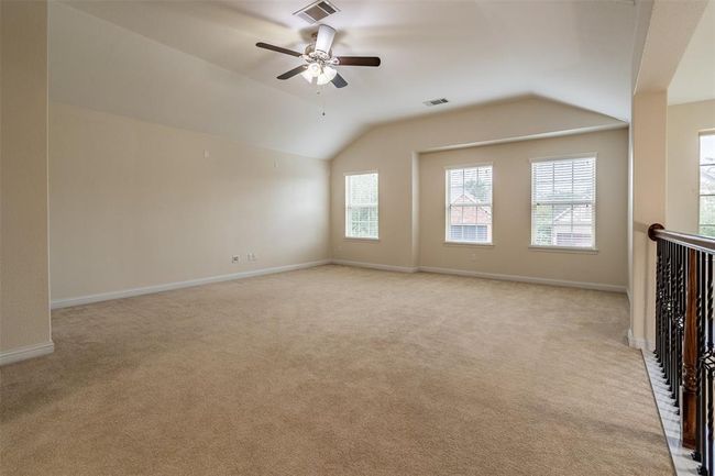 Unfurnished living room featuring light carpet, lofted ceiling, and ceiling fan | Image 9
