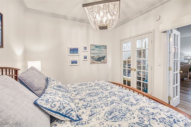 Bedroom with french doors, ornamental molding, wood finished floors, and a chandelier | Image 42