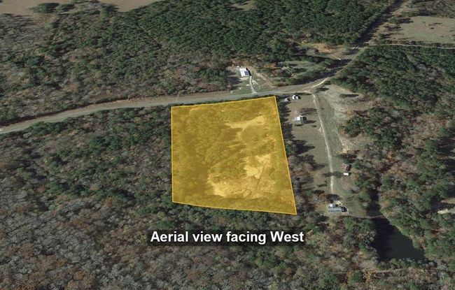 This aerial photo shows the property outlined in yellow, surrounded by dense trees and open land. It's a secluded area, ideal for privacy and nature lovers. | Image 23