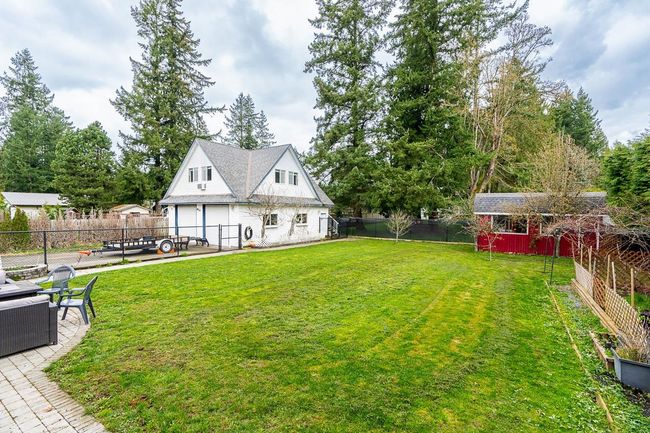 View of yard featuring a patio, driveway, a garage, and a fenced backyard | Image 34