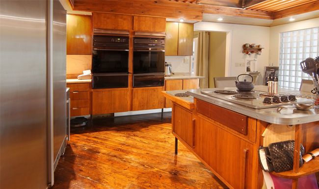 The electric cooktop could easily be converted to gas (lines are already in place); such unique storage all around the rooom; vintage glass block wall; and sliding doors leading to the porch (not visible here)...talk about Heart of the Home! | Image 12