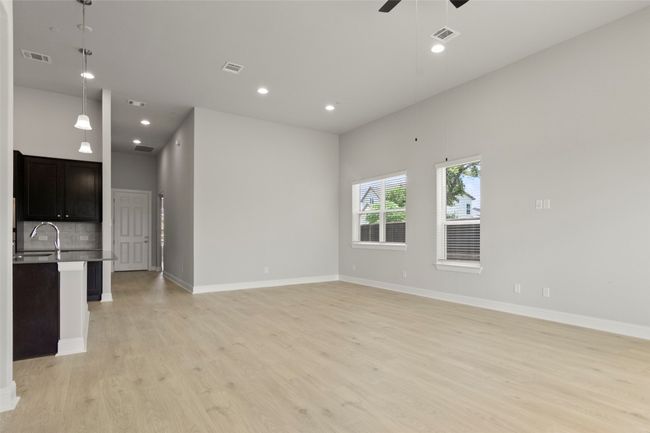 Unfurnished living room with light wood-style flooring, ceiling fan, and recessed lighting | Image 13