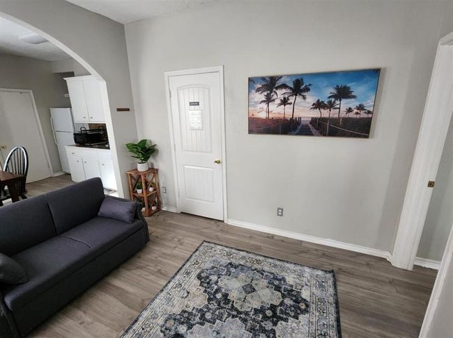 Stylish living room in a cozy one-bedroom unit, featuring elegant flooring and a welcoming ambiance. | Image 18
