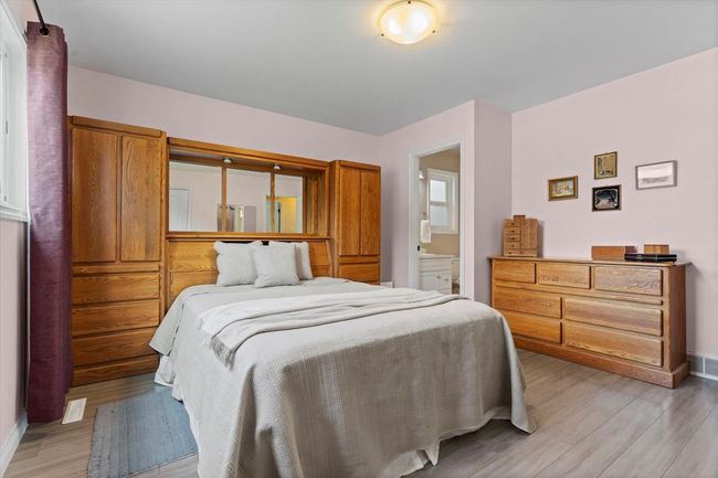 Bedroom with light wood-style floors and ensuite bathroom | Image 24