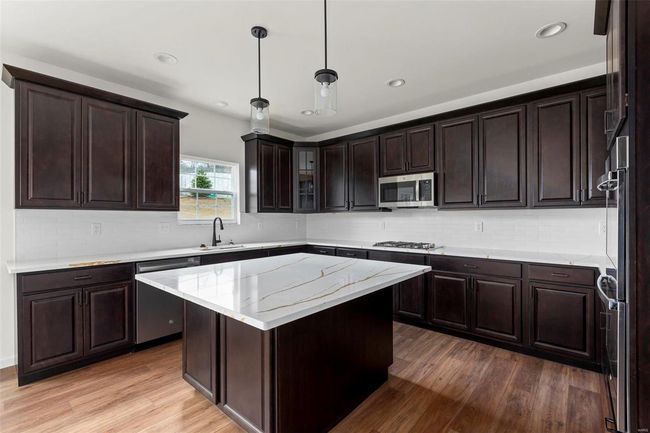 Kitchen with appliances with stainless steel finishes, light hardwood / wood-style flooring, hanging light fixtures, and sink | Image 22