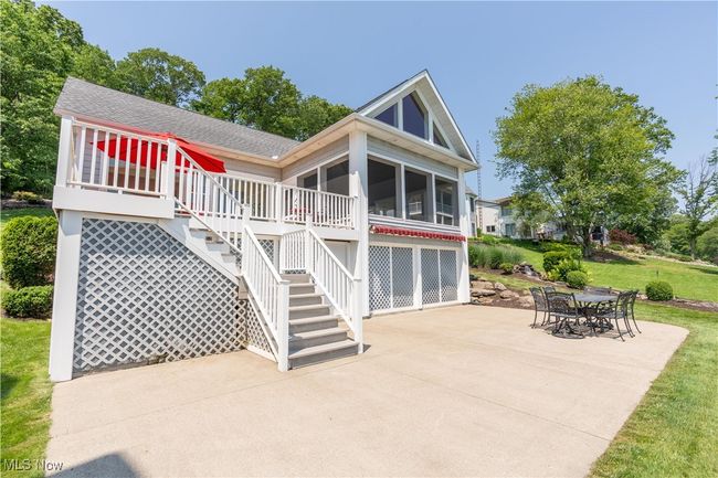 Rear view of property featuring a patio, a shingled roof, a sunroom, and a yard | Image 15