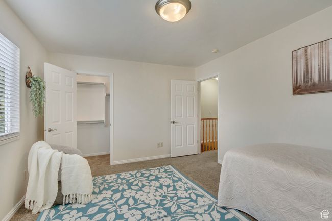 Bedroom featuring a spacious closet, carpet floors, and baseboards | Image 12