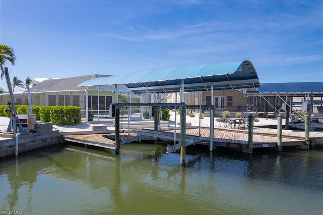 Dock area with a lanai and a water view. | Image 24