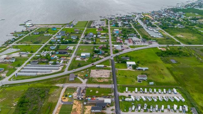 A wider aerial reveals proximity to the bay, with water glinting in the distance—emphasizing the property’s coastal setting. | Image 38