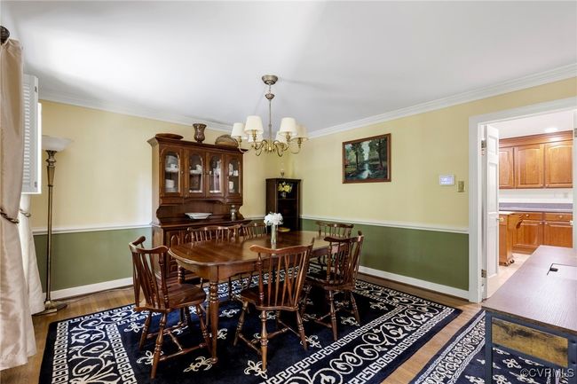 Dining space featuring a chandelier, light wood finished floors, and crown molding | Image 6