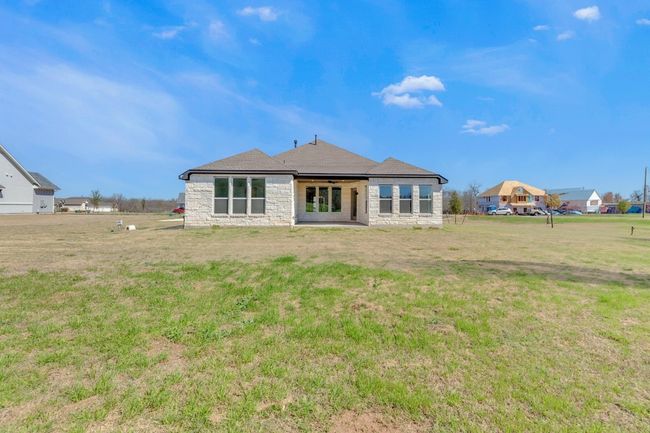 Rear view of property with stone siding and a lawn | Image 38