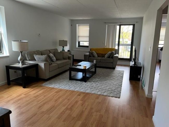 Living area with light wood-style floors and baseboards | Image 8