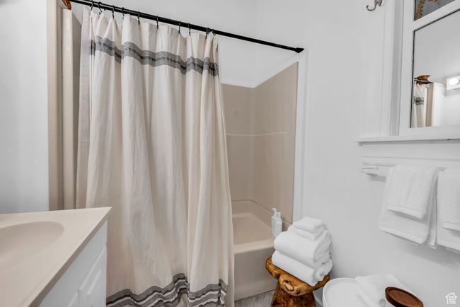 Bathroom with toilet, shower / bathtub combination with curtain, and vanity | Image 15