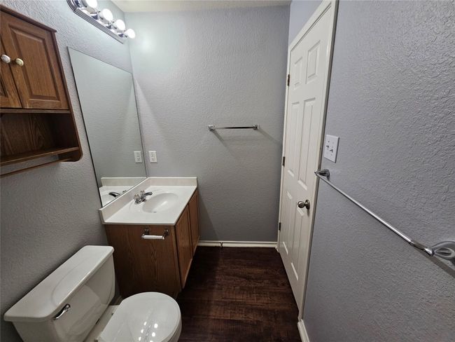 Bathroom with wood finished floors, vanity, and a textured wall | Image 27
