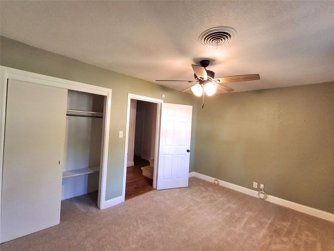 Unfurnished bedroom featuring light carpet, baseboards, a closet, and a textured ceiling | Image 23