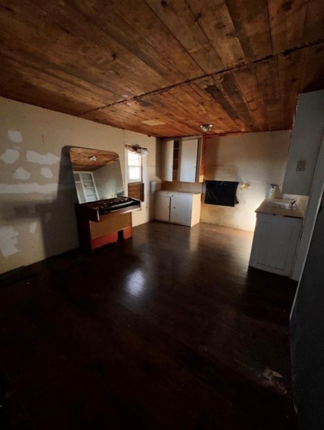 Unfurnished living room with wooden ceiling and dark wood-type flooring | Image 14