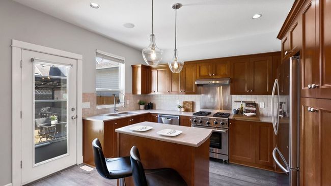 Kitchen with appliances with stainless steel finishes, a sink, light wood-style floors, and under cabinet range hood | Image 10