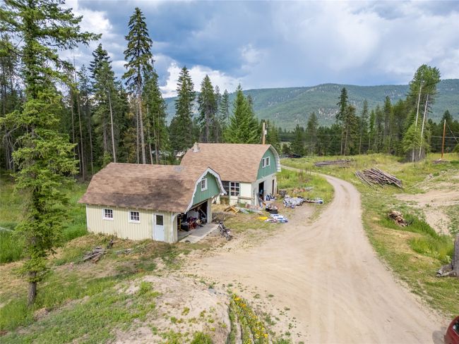 Aerial view of property and surrounding area featuring a forest and mountains | Image 17