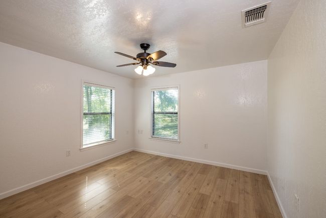 Empty room featuring baseboards, visible vents, light wood-type flooring, and a ceiling fan | Image 17